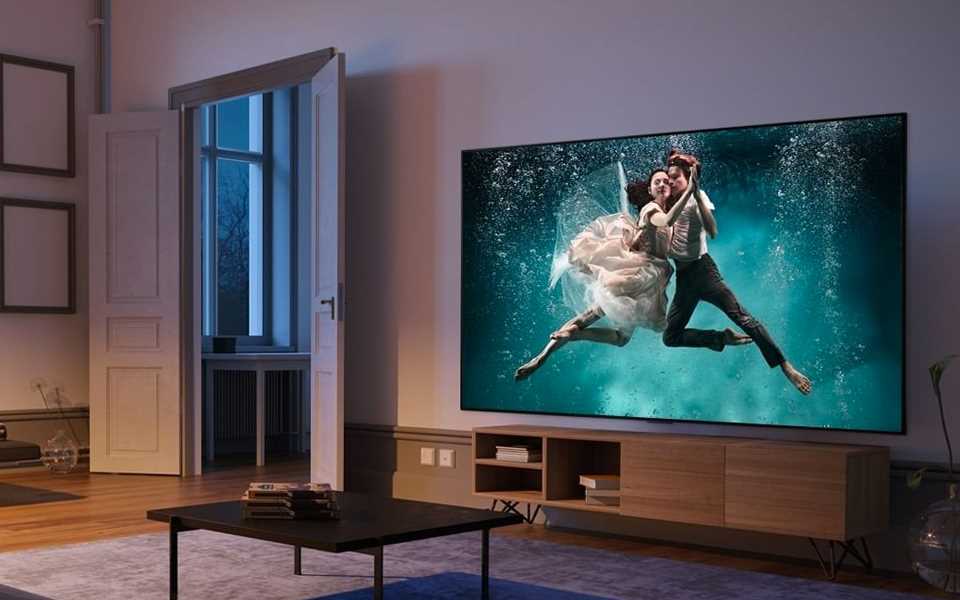 Canapé devant grand téléviseur en salle de cinéma à la maison